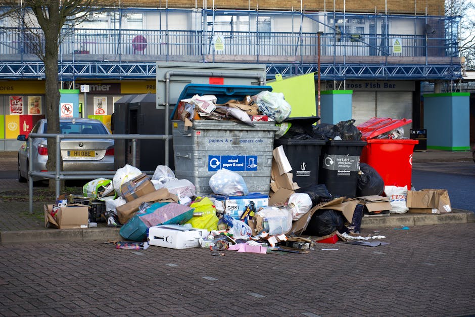 A person's hand is visible holding a sticker with a blue atom symbol in the foreground. The individual is wearing a purple and gray striped shirt, with part of their shoulder and arm slightly blurred.